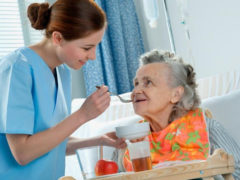Nurse feeding a resident at a nursing home