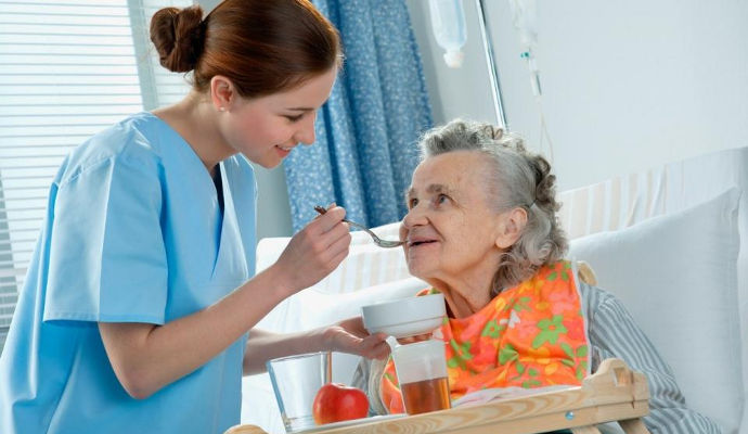 Nurse feeding a resident at a nursing home