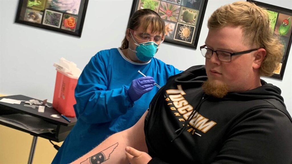 Colton James Edwards, a student at Tusculum University in Tusculum, Tennessee, receives a COVID-19 shot at Plateau Pediatrics in Crossville.